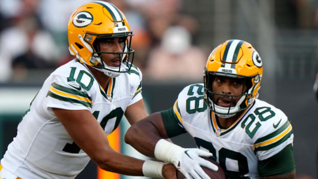 Packers quarterback Jordan Love passes the ball onto running back AJ Dillon.